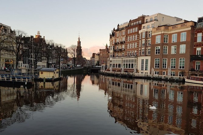 An Amsterdam canal at first light, the Montelbaanstoren standing over the water