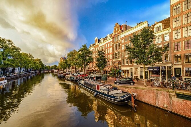 Houseboats moored along a tree-lined Amsterdam canal