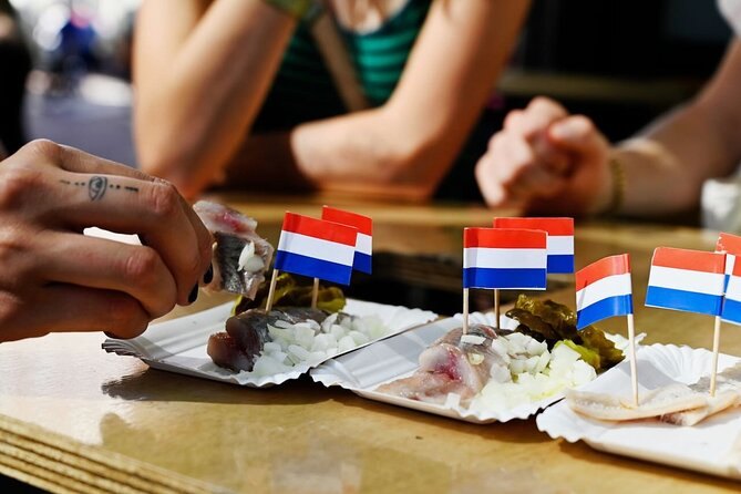 Raw herring served with onions and a Dutch flag on a market stall plate