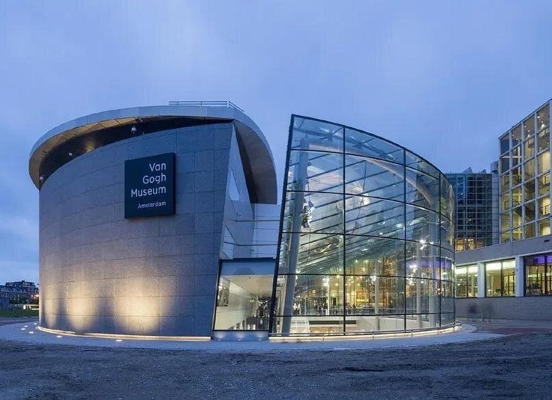 The Van Gogh Museum's glass entrance building at dusk